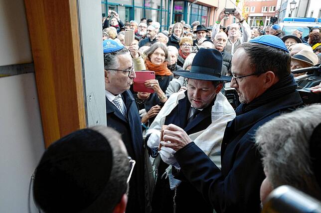 Amtshandlung des Landesrabbiners: Moshe Flomenmann (Mitte) bringt an der neuen Synagoge von Konstanz eine rituelle Kapsel an. Rechts von ...