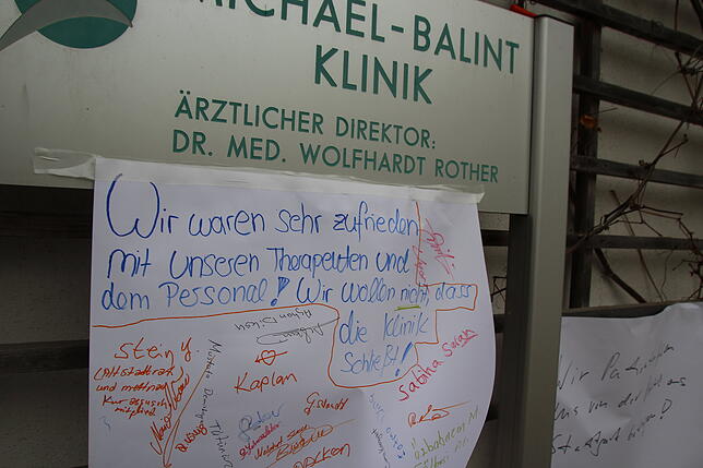 Patienten haben am Eingang der Klinik Plakate aufgehängt.