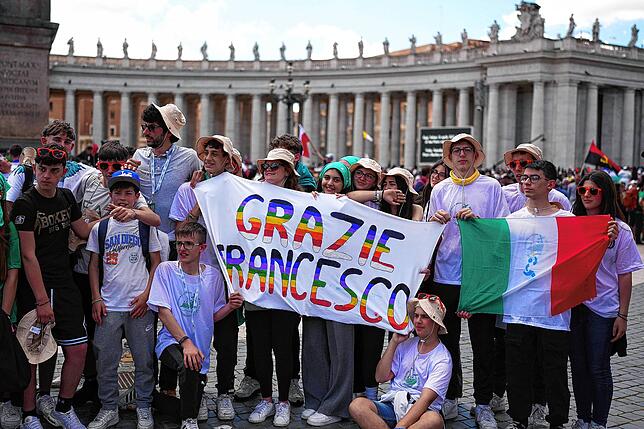 Jugendliche halten während der Trauerfeier auf dem Petersplatz ein Transparent mit der Aufschrift „Grazie Francesco“