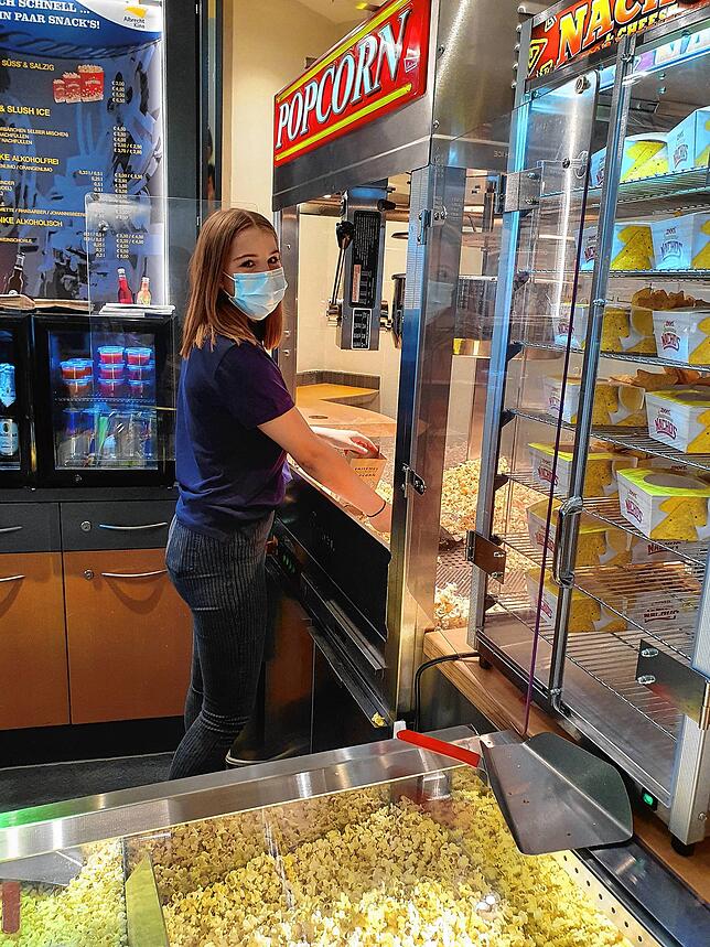Endlich wieder Popcorn: Mitarbeiterin Duygu Hartert schöpft den leckeren Kino-Snack in eine Papiertüte.