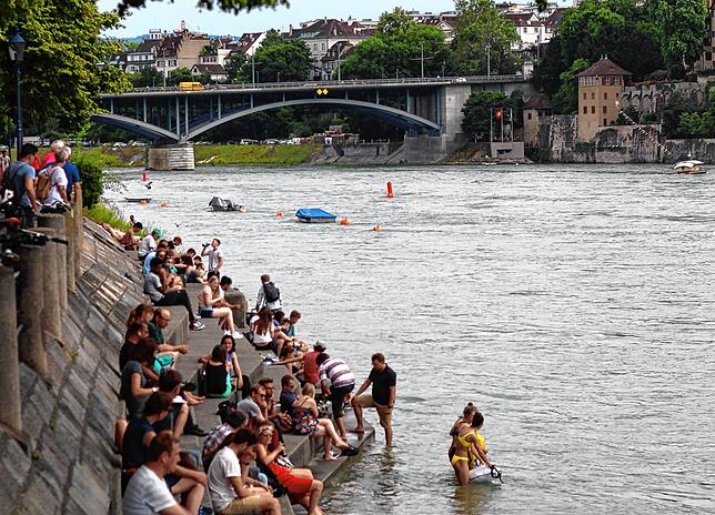 Bei sommerlicher Hitze zieht es viele Menschen ans Rheinufer, wie hier bei Basel. (Archivbild 2019)