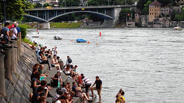 Bei sommerlicher Hitze zieht es viele Menschen ans Rheinufer, wie hier bei Basel. (Archivbild 2019)