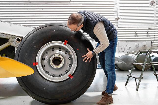 Björn Riedesel, Geschäftsführer der Quax Technik GmbH, steht an einem Rad der alten Junkers.