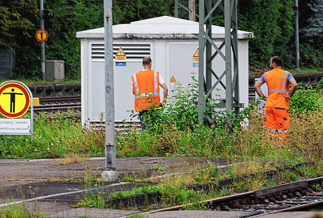 Techniker am Schalthäuschen zwischen den Bahnschienen, in dem der Stromausfall behoben werden musste.