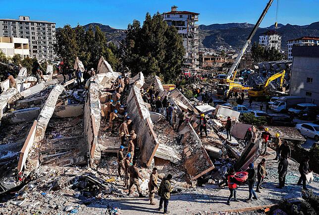 Rettungskräfte durchsuchen Trümmer von eingestürzten Gebäuden in Hatay nach Überlebenden.