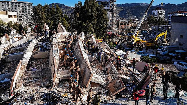 Rettungskräfte durchsuchen Trümmer von eingestürzten Gebäuden in Hatay nach Überlebenden.