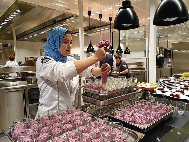 Mariam El ouachani, Mitarbeiterin in der Patisserie, füllt eine Heidelbeer-Mascarpone-Creme in Dessertgläser.