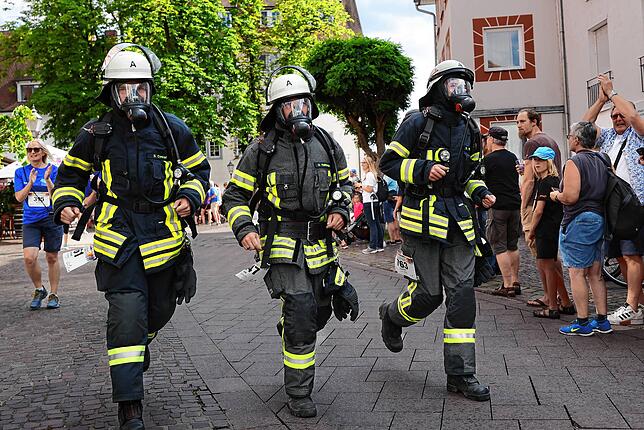 In voller Montur laufen die drei Feuerwehrleute Simon Conrad, Uwe Haltmaier und Daniel Hafner (von links) beim Firmenlauf mit.