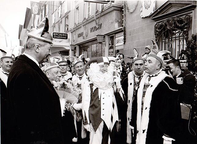 Empfang von Kurt-Georg Kiesinger am Schmotzigen Dunschtig, 25. Februar 1965, vor dem Rathaus in der Hauptstraße (v.l.): Gerichtsnarr ...