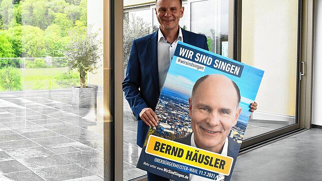 Original und Foto: Bernd Häusler, Singener Oberbürgermeister und bislang einziger Bewerber für die OB-Wahl am 11. Juli, mit Wahlplakat.