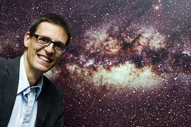 Physik-Nobelpreis für Erforscher des Kosmos Der Schweizer Astrophysiker Didier Queloz vor dem Bild der Milchstraße.