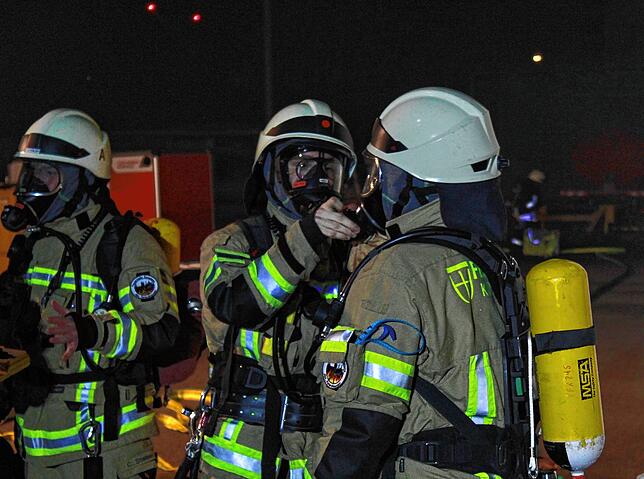 Knappe fünf Minuten nach dem ersten Notruf trifft die Feuerwehr ein, die schweren Atemschutzgeräte werden angelegt, um die Verletzten zu ...
