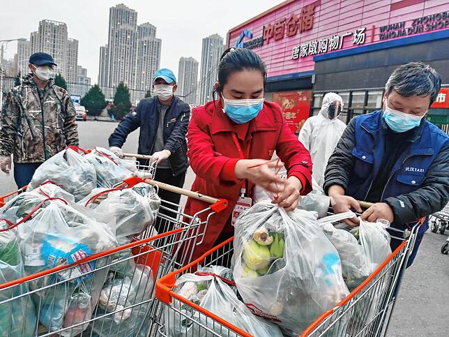 China, Wuhan: Freiwillige und Mitarbeiter verpacken frisches Gemüse für die Anwohner einer Gemeinde die aus Maßnahme gegen die ...