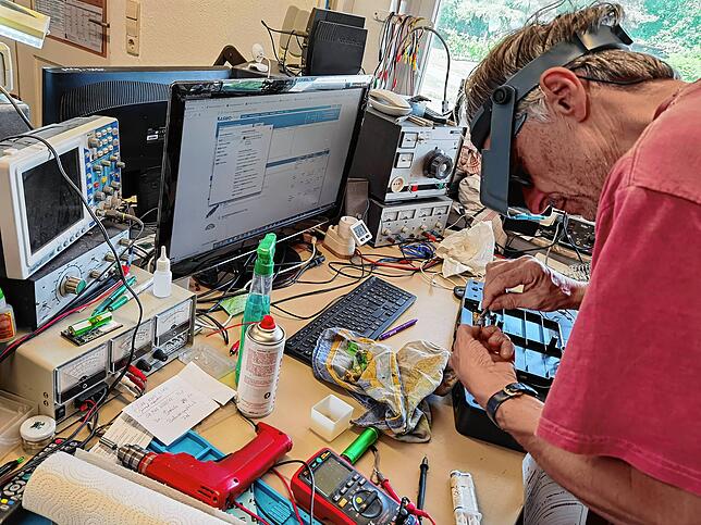 Günter Neubert an seinem Arbeitsplatz: Wichtigste Geräte sind der Trenntrafo rechts für das gefahrlose Testen sowie ein Labornetzgerät ...