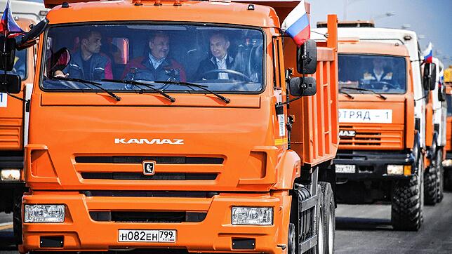 Russlands Präsident Wladimir Putin (rechts) sitzt 2018 in einem Kamaz-Truck, der über die neu eröffnete Brücke auf die Halbinsel Krim ...