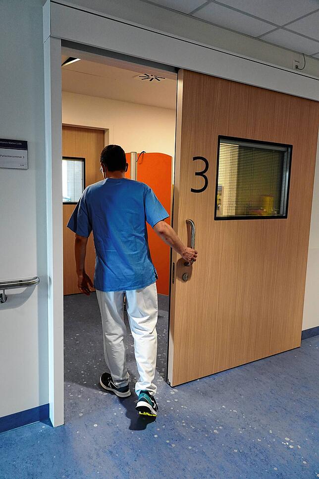 Christian Sprink, der die Leitung der Pflege auf der Intensivstation innehat, betritt die Schleuse zum Isolierzimmer, in dem eine ...