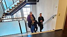 Mit Hand- und Fußfesseln läuft der Angeklagte (rechts) in Begleitung die Treppe Richtung Gerichtssaal hinauf.