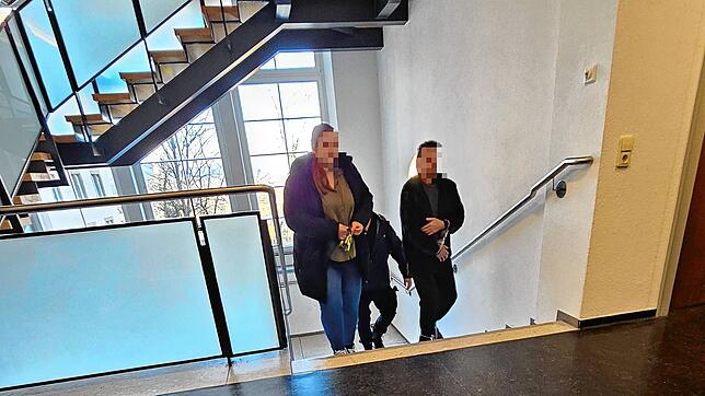 Mit Hand- und Fußfesseln läuft der Angeklagte (rechts) in Begleitung die Treppe Richtung Gerichtssaal hinauf.