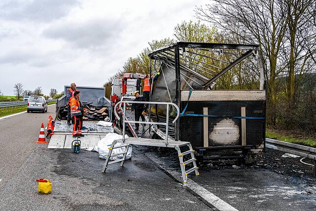 Hier sieht man den völlig zerstörten Anhänger, in dem Container nebendran liegen Reste der Ladung und des Aufbaus, Teile der Ladung ...