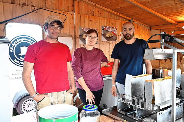 Jürgen Saric aus Deggenhausertal (links) mit Hannah und Arkan in ihrer Hütte im Infield. Sie verkaufen Schweizer Raclette.
