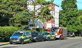 Die Polizei steht mit mehreren Streifenwagen und einem Hundeführer am Freitagmorgen in der Grabenäckerstraße – die Feuerwehr ist auch ...