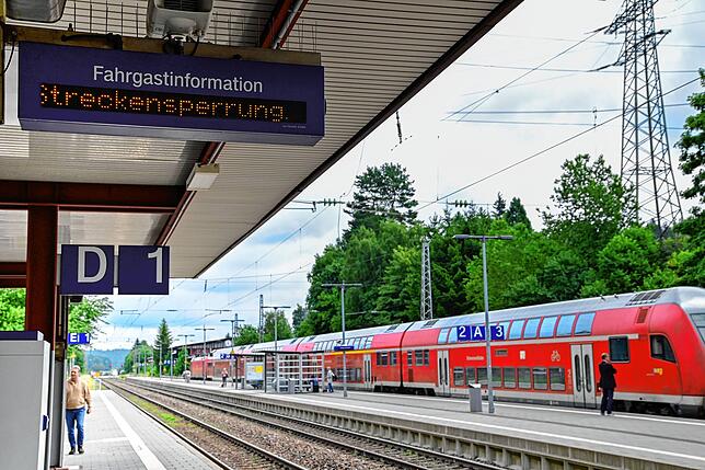 Am Bahnhof in St. Georgen wird auf die Streckensperrung hingewiesen. Der Zug im Hintergrund wartet auf Fahrgäste, die per Ersatzverkehr ...