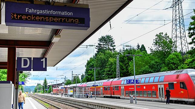 Am Bahnhof in St. Georgen wird auf die Streckensperrung hingewiesen. Der Zug im Hintergrund wartet auf Fahrgäste, die per Ersatzverkehr ...