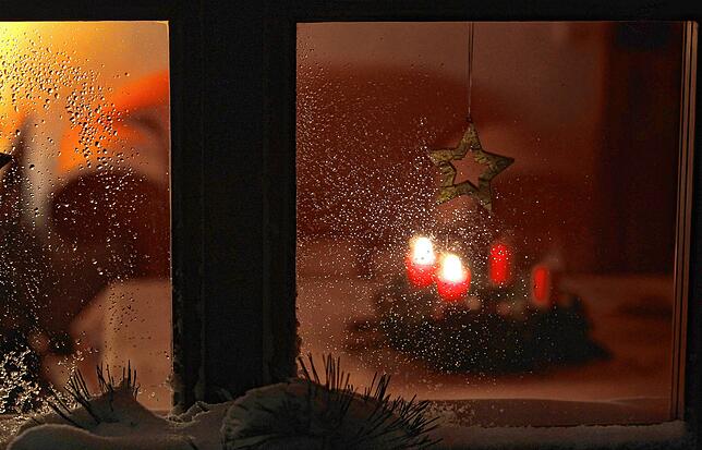 Hinterm Fenster ein Adventskranz, zwei brennende Kerzen – mehr braucht es nicht für das Fest des Lichts.
