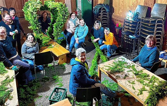 Beim Binden der Thuja in der Pfarrschür haben die Frauen viel Spaß miteinander.