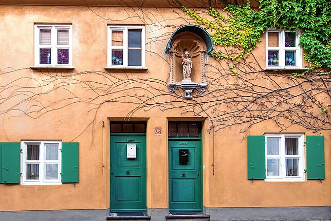 Typisches Fuggerei-Wohnhaus mit grünen Türen und Fensterläden.