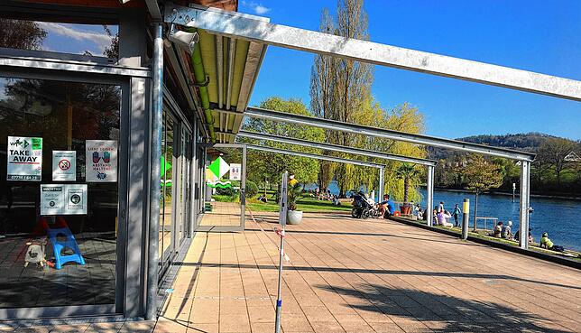Das Restaurant am Gailinger Rheinuferpark darf nur Speisen zum Mitnehmen verkaufen. Die Terrasse bleibt leer. Die Gäste verteilen sich ...