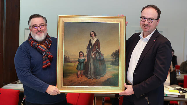 Anselm Venedey übergibt ein Bild des Malers Friedrich Pecht an Uli Burchardt: es zeigt eine Frau mit Kind und steht für den Wunsch, dass ...