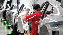 Ein Mitarbeiter der Porsche AG montiert im Stammwerk in Zuffenhausen einen vollelektrischen Porsche Taycan.