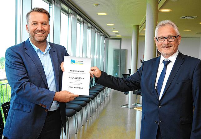 Oberteuringens Bürgermeister Ralf Meßmer (links) freut sich über den Zuschussbescheid über rund 4,5 Millionen Euro aus der Hand des ...