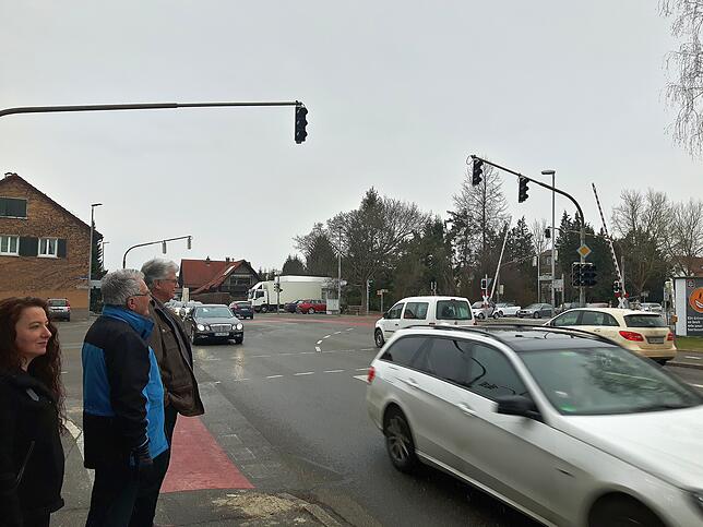 Anwohner Beobachten den Verkehr an der Kreuzung beim Bahnübergang kurz nach einer kompletten Rotphase, nachdem ein Zug durchgefahren ist ...