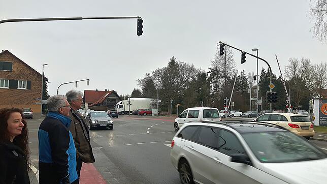 Anwohner Beobachten den Verkehr an der Kreuzung beim Bahnübergang kurz nach einer kompletten Rotphase, nachdem ein Zug durchgefahren ist ...