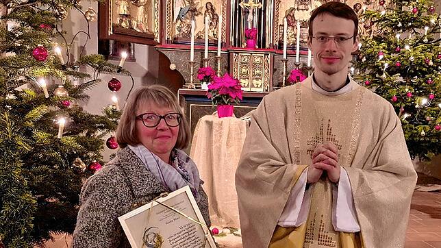 Pfarrer Thomas Stricker würdigt die Jubilarin Gisela Meyer, auch für deren großen Einsatz für den Kirchenchor. Bild: Kirchenchor ...