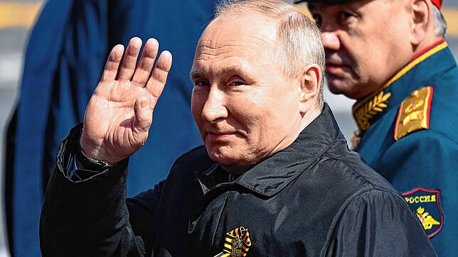 Russlands Präsident Wladimir Putin winkt bei der Militärparade am 9. Mai, an seiner Seite Verteidigungsminister Sergej Schoigu.