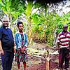 Father Peter Mubunga Basaliza mit Farmern auf der Bananenplantage.