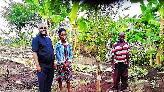 Father Peter Mubunga Basaliza mit Farmern auf der Bananenplantage.