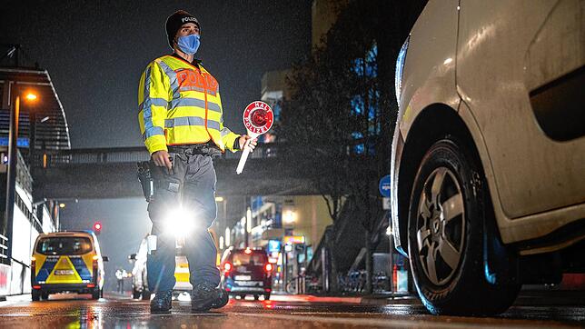 Ein Polizeibeamter winkt bei einer Verkehrskontrolle zur Einhaltung der coronabedingten Ausgangsbeschränkungen im Südwesten ein Auto ...