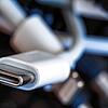 Ein Ladekabel mit USB-C-Stecker liegt neben einem Bündel unterschiedlicher Anschlusskabel. Ab 2024 soll es in der EU einheitliche ...