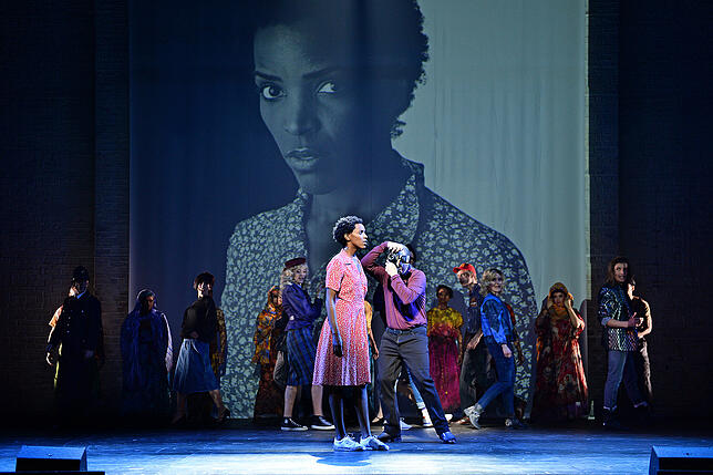 Waris Dirie (Kerry Jean) wird in Europa als Model entdeckt. Die Inszenierug arbeitet hier mit Videoeinspielungen.