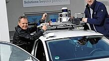 LFT-Mitarbeiter Thomas Münsterer (links) und Christian Samuelis, montieren Sensoren auf ein Test-Fahrzeug.