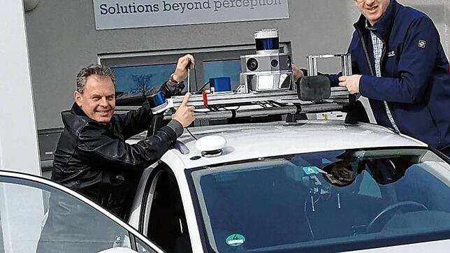 LFT-Mitarbeiter Thomas Münsterer (links) und Christian Samuelis, montieren Sensoren auf ein Test-Fahrzeug.