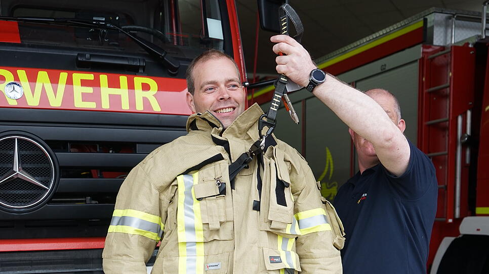 Timo Hestler demonstriert den integrierten Rettungsgurt seines neuen Feuerwehranzugs.