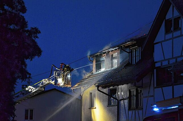 Von der Drehleiter und der Straße aus wird am frühen Dienstagmorgen auf den Brand eingewirkt.