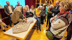 Anhand seines selbstgeschnitzten Modells erläutert Stadtplaner Thomas Hirthe den Bürgern die Pläne für die Ortsmitte.