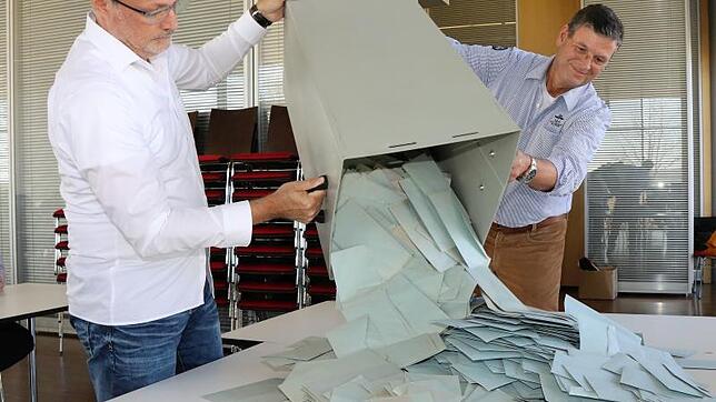 Wolfgang Giess (links) und Rolf Sprinz, beide Mitglieder des Wahlvorstands, leeren eine der Wahlurnen für die Auszählung der ...