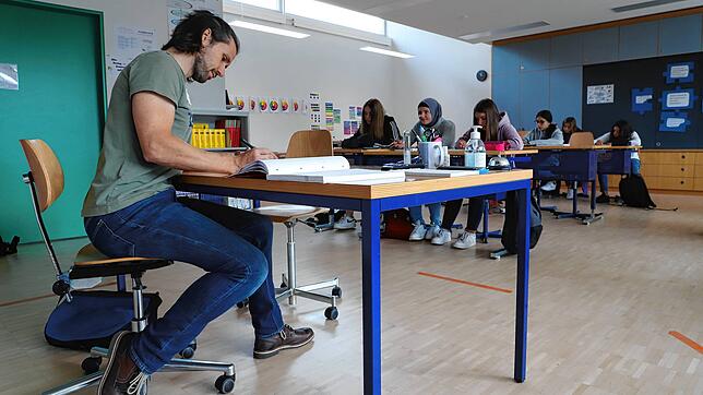 Nur die Abstandsmarkierungen am Boden und das Desinfektionsmittel auf dem Lehrertisch erinnern in diesem Klassenzimmer des ...
